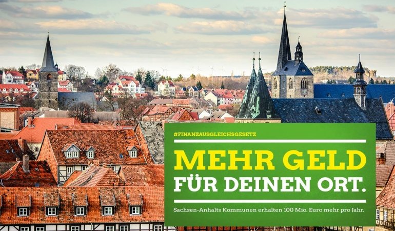 Sharepic Stadtsilouette mit grünem Infokasten Mehr Geld für deinen Ort.