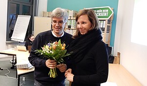 Olaf Meister und Vorstandsmitglied Petra Sperling mit Blumenstrauß.