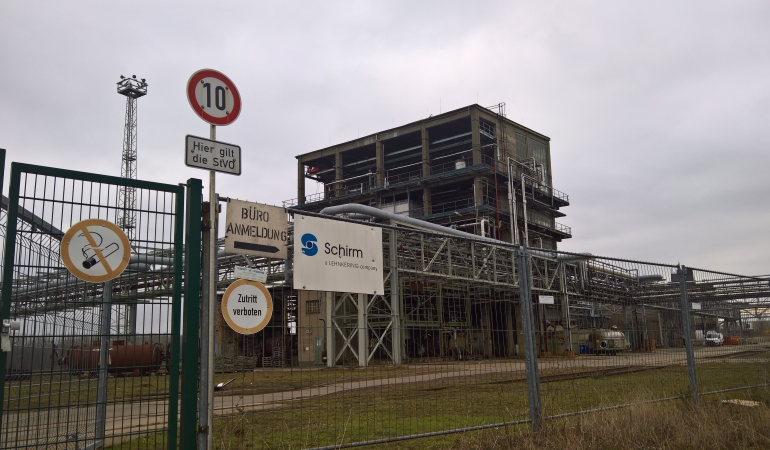 Magdeburg Alt-Salbke Einfahrt mit Schild Schirm AG. Im Hintergrund ein Chemiekomplex.