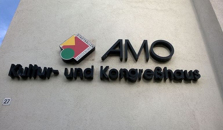 Logo des AMO an der Hauswand.