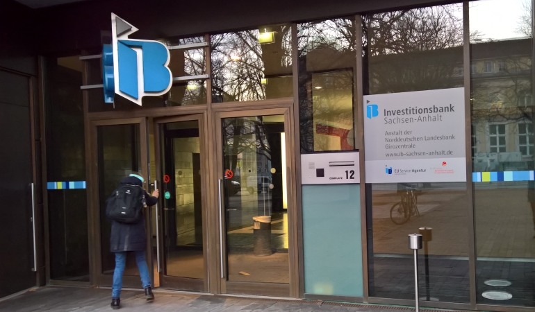 Eine Person öffnet den Gläserner Eingang am Domplatz 12, dem Eingang zur IB Sachsen-Anhalt. Eine Person öffnet den Gläserner Eingang am Domplatz 12, dem Eingang zur IB Sachsen-Anhalt.