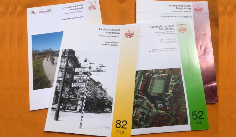 Mehrere Ausgaben der Weißen Reihe des Stadtplanungsamt auf einem Tisch liegend.