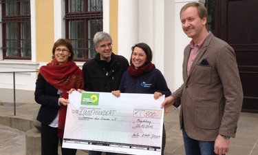 Dorothea Frederking, Olaf Meister, Franka Kretschmer und Sören Herbst bei der Scheckübergabe vor dem Landtag.