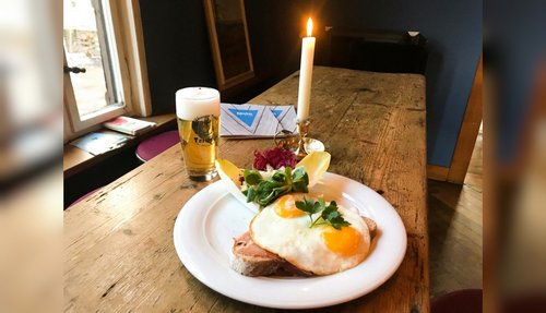 Gasthof mit Holztisch, einer Portion Strammer Max und einem frisch gezapftem Bier