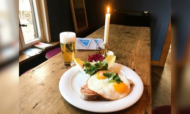 Gasthof mit Holztisch, einer Portion Strammer Max und einem frisch gezapftem Bier