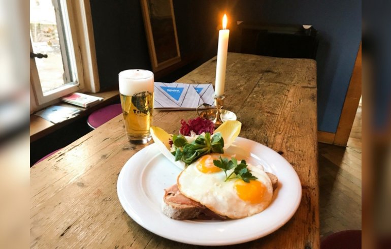 Gasthof mit Holztisch, einer Portion Strammer Max und einem frisch gezapftem Bier