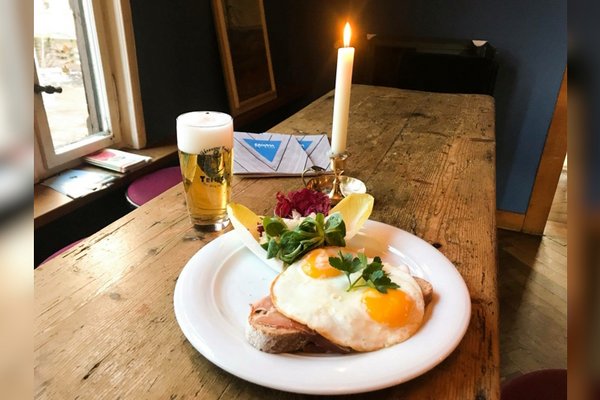 Gasthof mit Holztisch, einer Portion Strammer Max und einem frisch gezapftem Bier