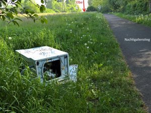 Alte Waschmaschine liegt auf der Wiese neben dem Nachtigallenstieg.