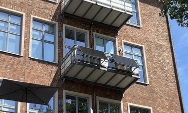 Wohngebäude mit Außenbalkon und Solarbalkonkraftwerk