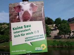 Plakat zum Bürgerbegehren gegen den Schlachthof in Bernburg vor der Silouhette Bernburgs.