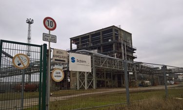 Magdeburg Alt-Salbke Einfahrt mit Schild Schirm AG. Im Hintergrund ein Chemiekomplex.